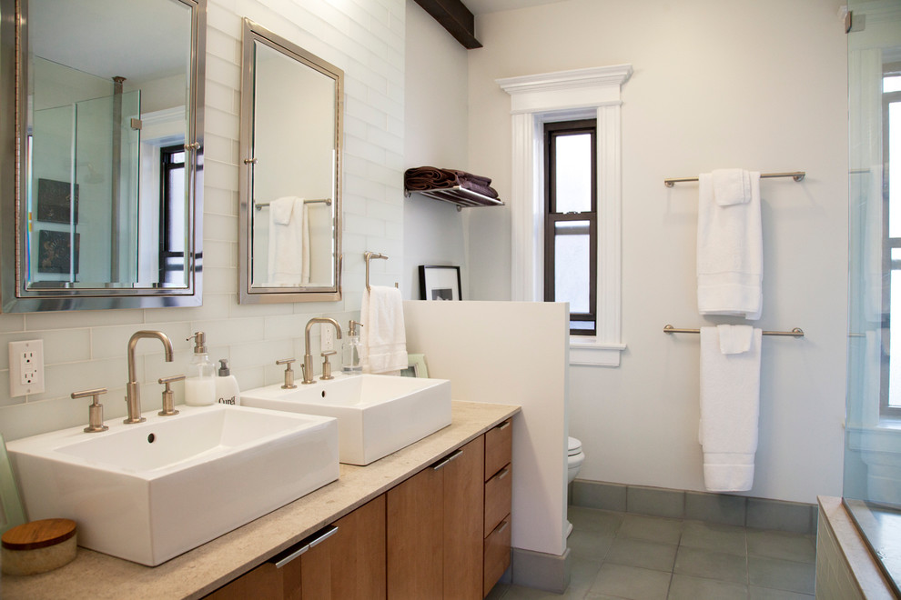 На фото: большая главная ванная комната в современном стиле с настольной раковиной, плоскими фасадами, фасадами цвета дерева среднего тона, белой плиткой, белыми стенами и серым полом с