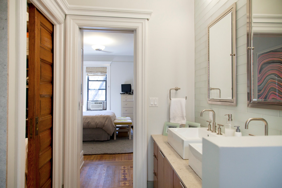 Modelo de cuarto de baño principal contemporáneo grande con armarios con paneles lisos, puertas de armario de madera oscura, baldosas y/o azulejos blancos, paredes blancas, lavabo sobreencimera y suelo gris