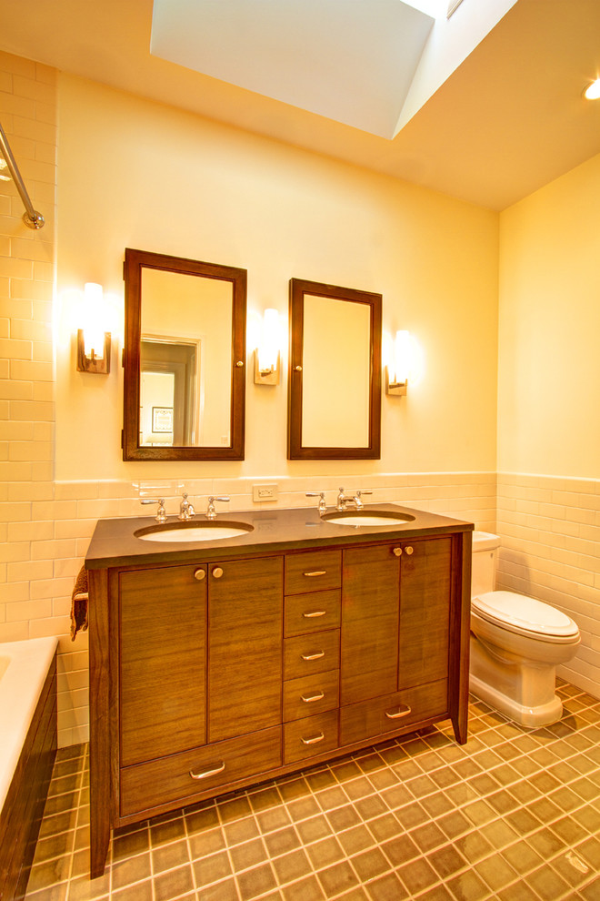 Elegant beige tile and subway tile bathroom photo in New York with an undermount sink, furniture-like cabinets, dark wood cabinets, quartz countertops and a one-piece toilet