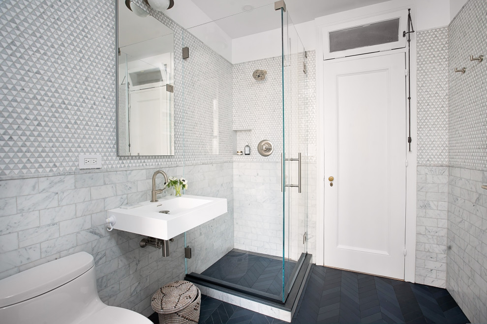 Пример оригинального дизайна: маленькая ванная комната в современном стиле с унитазом-моноблоком, серой плиткой, плиткой мозаикой, белыми стенами, полом из керамогранита, подвесной раковиной, черным полом, угловым душем, душем с распашными дверями и тумбой под одну раковину для на участке и в саду