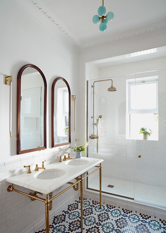 ニューヨークにある中くらいなトランジショナルスタイルのおしゃれな浴室 (アルコーブ型シャワー、白いタイル、コンソール型シンク、マルチカラーの床、開き戸のシャワー、白い壁、モザイクタイル、白い洗面カウンター) の写真