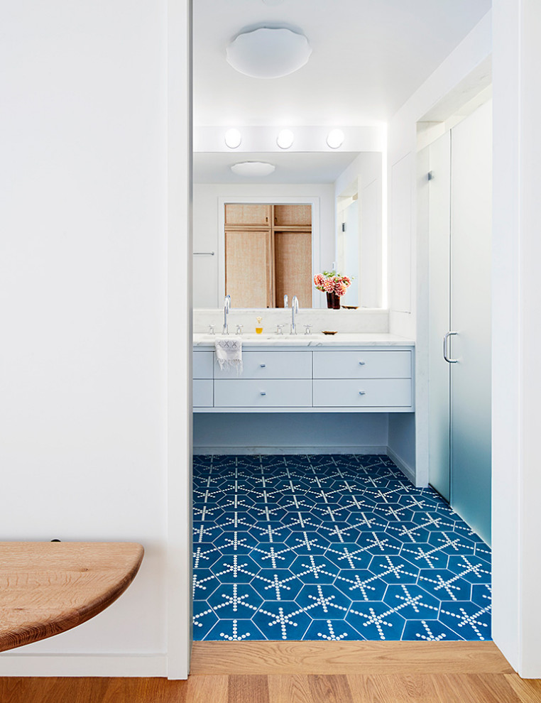 Diseño de cuarto de baño principal vintage de tamaño medio con puertas de armario blancas, ducha empotrada, paredes blancas, suelo azul, ducha con puerta con bisagras y encimeras blancas
