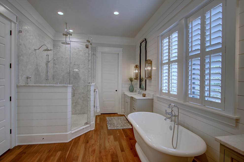 Exempel på ett stort klassiskt en-suite badrum, med skåp i shakerstil, vita skåp, ett fristående badkar, en dubbeldusch, vit kakel, vita väggar, mellanmörkt trägolv, ett undermonterad handfat och marmorbänkskiva