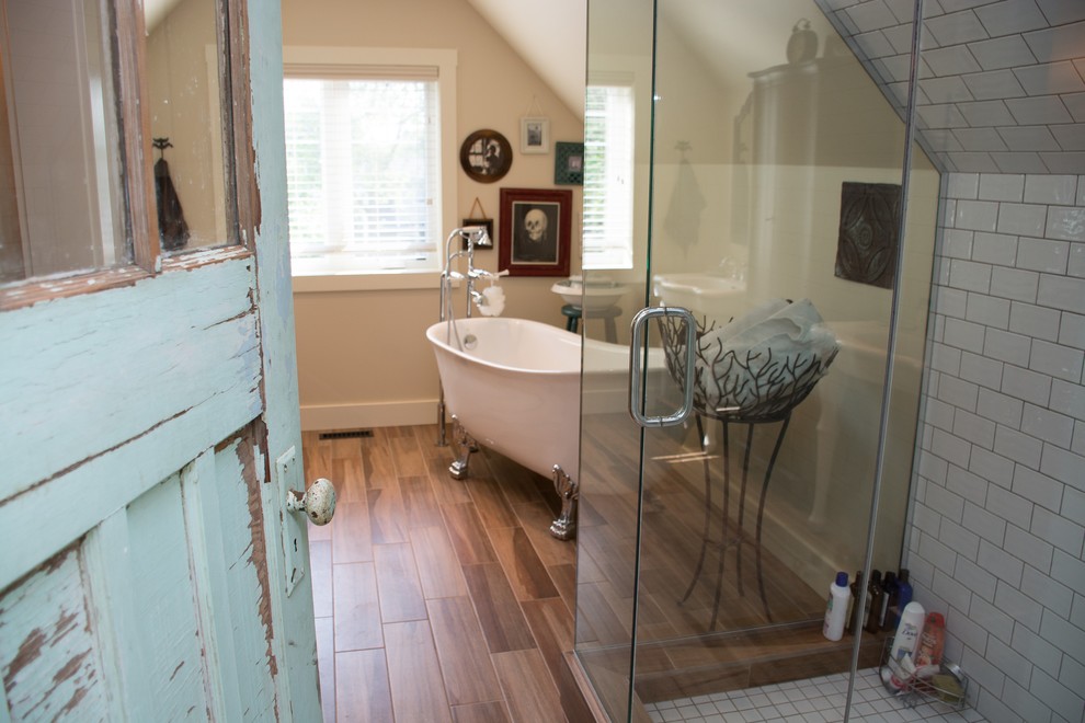 Cette image montre une salle de bain principale bohème de taille moyenne avec une baignoire sur pieds, une douche d'angle, un carrelage marron, des carreaux de porcelaine, un mur beige et un sol en carrelage de porcelaine.