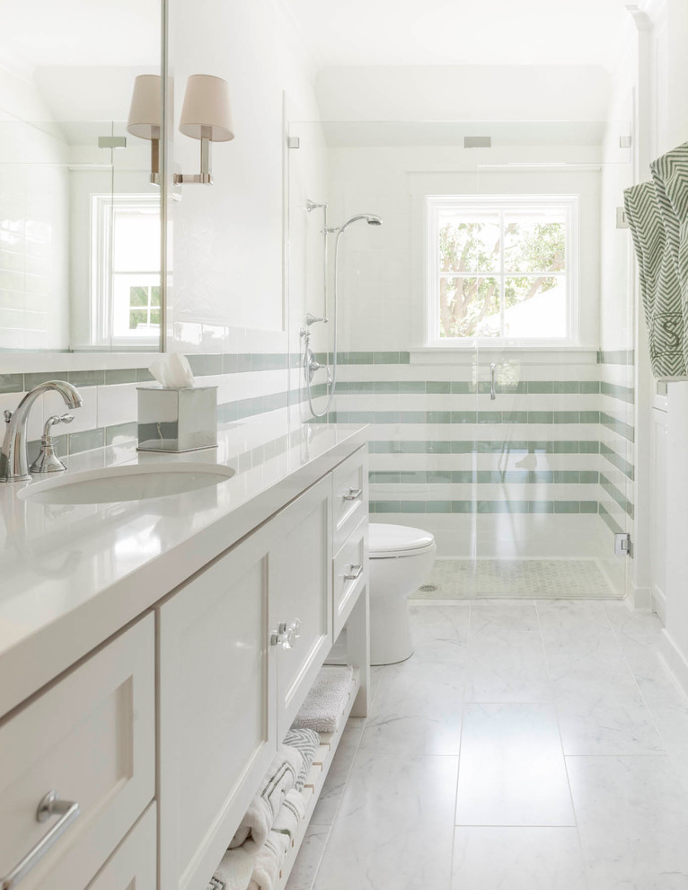 Bild på ett vintage badrum med dusch, med ett undermonterad handfat, skåp i shakerstil, vita skåp, en kantlös dusch, grön kakel, vit kakel och vita väggar