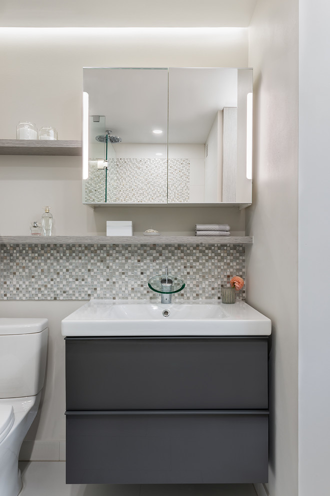 Idee per una piccola stanza da bagno contemporanea con ante in legno chiaro, vasca ad alcova, vasca/doccia, piastrelle grigie, piastrelle bianche e piastrelle in gres porcellanato