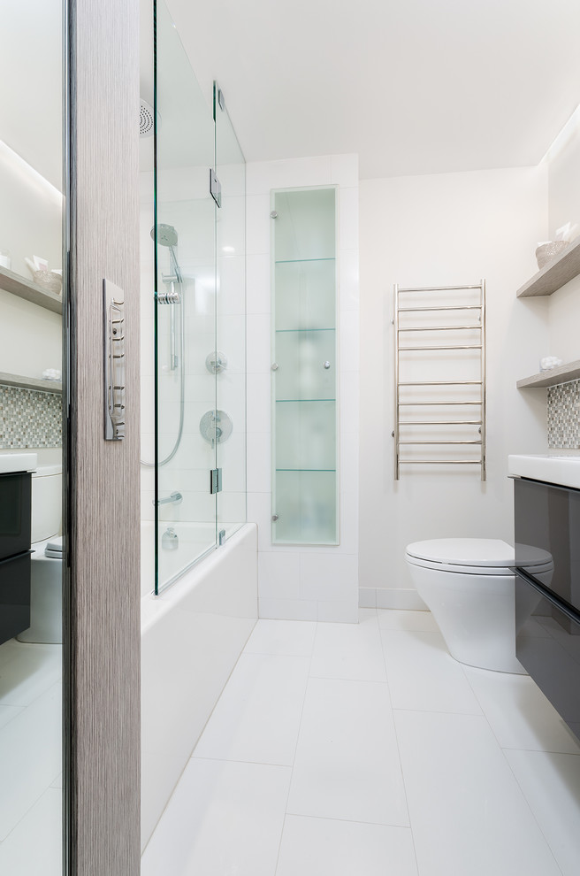 Foto di una piccola stanza da bagno minimal con ante in legno chiaro, vasca ad alcova, vasca/doccia, piastrelle grigie, piastrelle bianche e piastrelle in gres porcellanato