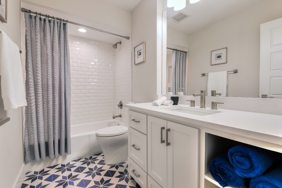 Immagine di una stanza da bagno minimalista con ante in stile shaker, ante bianche, vasca/doccia, piastrelle blu, piastrelle in ceramica, pareti grigie, pavimento con piastrelle in ceramica e lavabo sottopiano