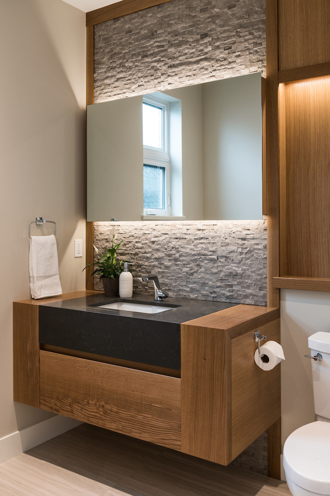 バンクーバーにあるコンテンポラリースタイルのおしゃれな浴室 (中間色木目調キャビネット、グレーのタイル、石タイル、ベージュの壁、アンダーカウンター洗面器、ベージュの床) の写真
