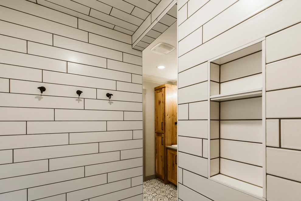 Example of a mid-sized farmhouse master white tile and subway tile ceramic tile and multicolored floor bathroom design in Other with shaker cabinets, medium tone wood cabinets, white walls, a drop-in sink, quartz countertops and gray countertops