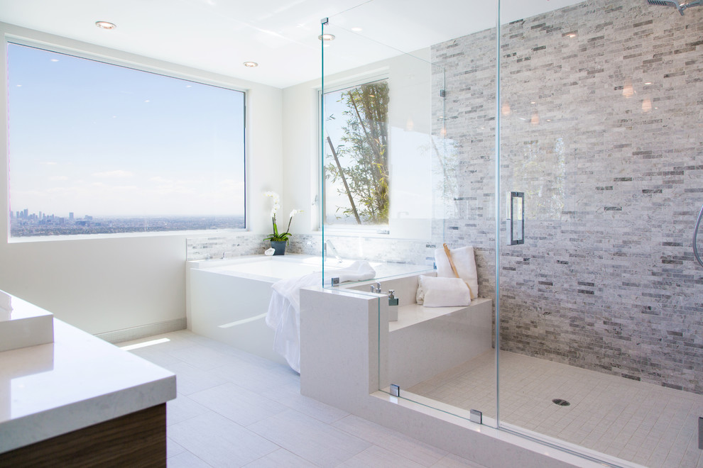 Photo of a large contemporary ensuite bathroom in Other with flat-panel cabinets, dark wood cabinets, a built-in bath, a corner shower, grey tiles, white tiles, stone tiles, white walls, porcelain flooring, a built-in sink, marble worktops, white floors and a hinged door.