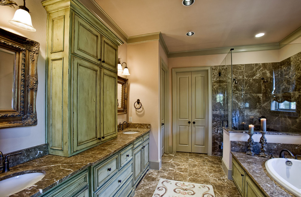 This is an example of a large traditional ensuite bathroom in Dallas with recessed-panel cabinets, green cabinets, a built-in bath, a corner shower, black and white tiles, stone slabs, white walls, marble flooring, a submerged sink and granite worktops.