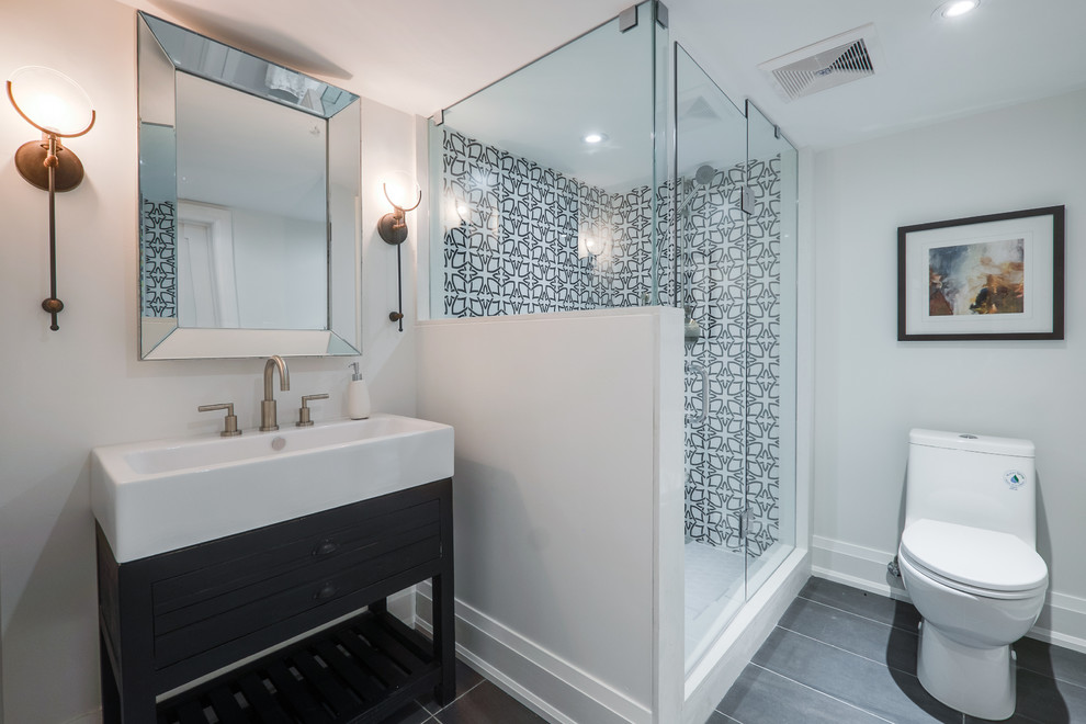 Пример оригинального дизайна: ванная комната среднего размера в современном стиле с плоскими фасадами, темными деревянными фасадами, угловым душем, унитазом-моноблоком, серой плиткой, керамогранитной плиткой, серыми стенами, полом из керамогранита, душевой кабиной, раковиной с несколькими смесителями, столешницей из искусственного кварца и душем с распашными дверями
