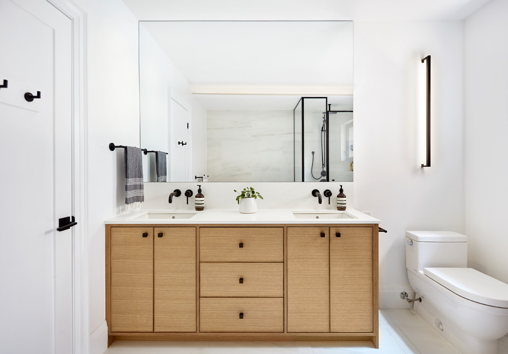 Modelo de cuarto de baño clásico renovado con armarios con paneles lisos, puertas de armario de madera oscura, sanitario de una pieza, paredes blancas, lavabo bajoencimera, suelo blanco y encimeras blancas