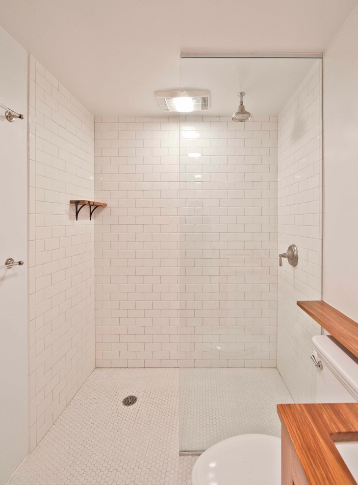 Inspiration pour une salle de bain design avec un carrelage métro et un plan de toilette en bois.
