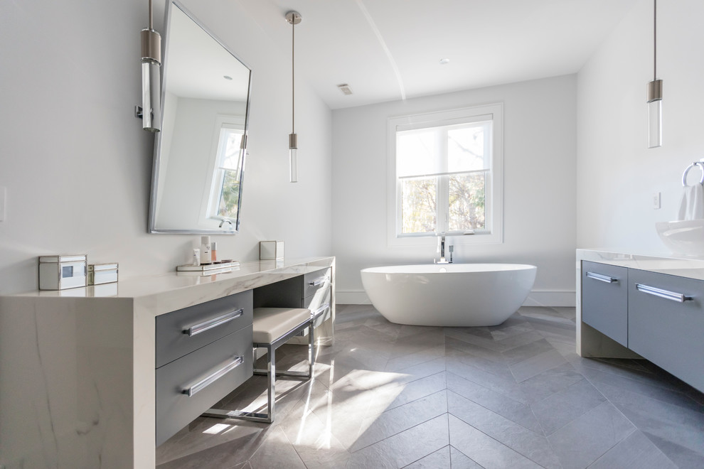 Свежая идея для дизайна: большая главная ванная комната в современном стиле с плоскими фасадами, серыми фасадами, отдельно стоящей ванной, белыми стенами, полом из сланца, настольной раковиной и мраморной столешницей - отличное фото интерьера