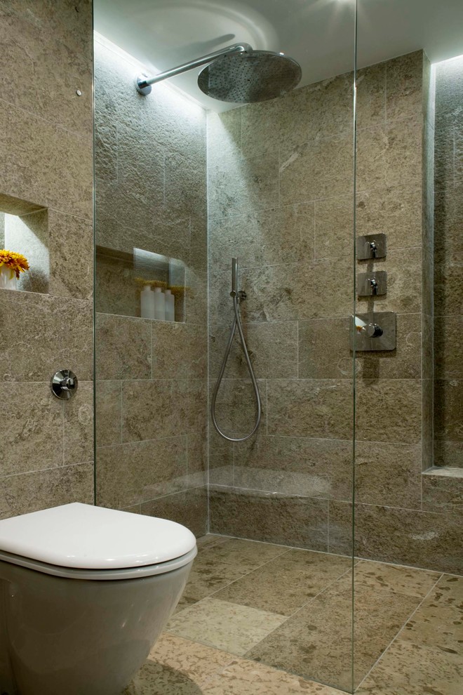 Стильный дизайн: главная ванная комната среднего размера в современном стиле с монолитной раковиной, столешницей из известняка, угловым душем, унитазом-моноблоком, каменной плиткой, серыми стенами и полом из известняка - последний тренд