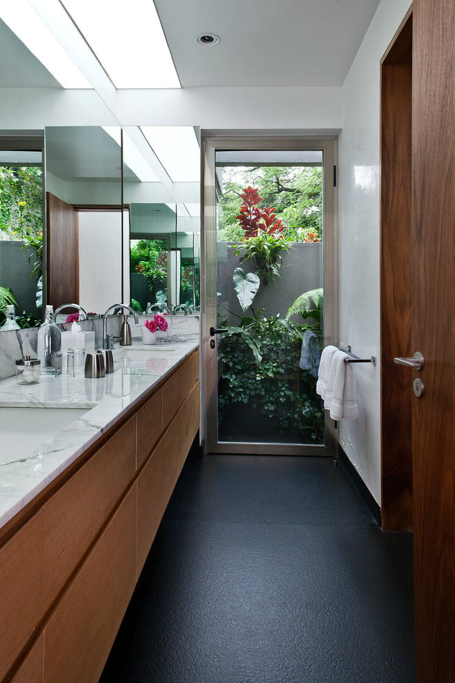 Modernes Badezimmer mit Unterbauwaschbecken, flächenbündigen Schrankfronten und hellbraunen Holzschränken in Mexiko Stadt