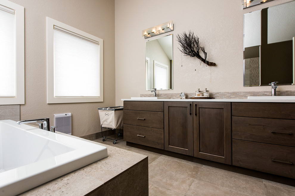 Example of a large trendy master beige tile and matchstick tile ceramic tile bathroom design in Other with flat-panel cabinets, dark wood cabinets, beige walls, a drop-in sink and solid surface countertops