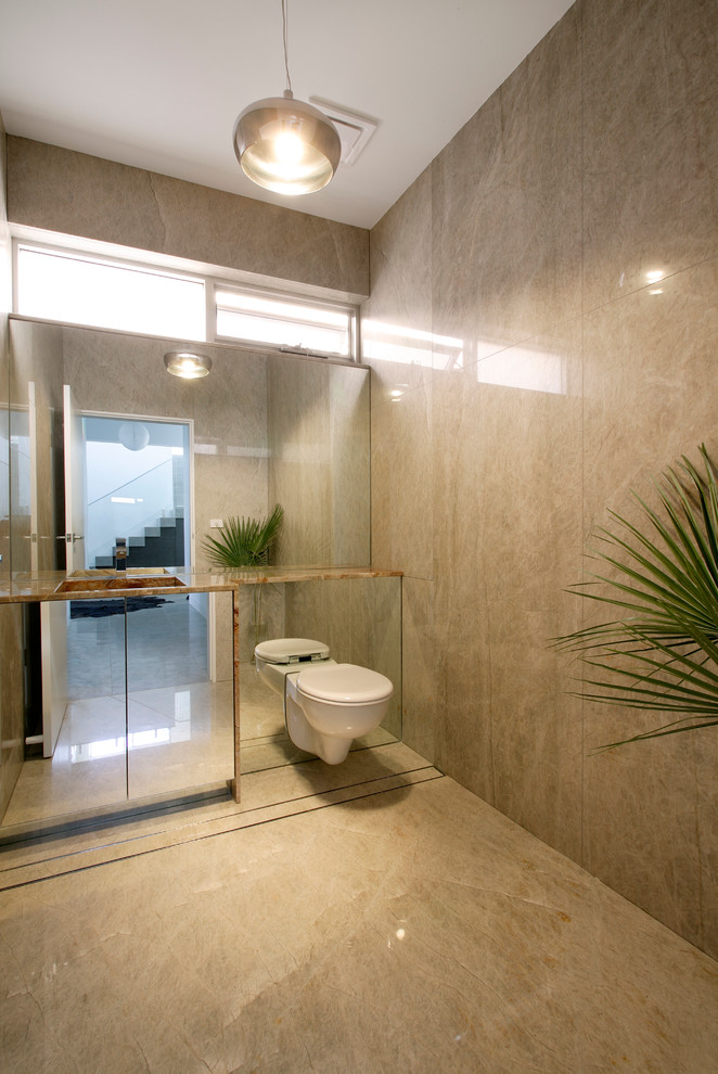 Пример оригинального дизайна: ванная комната с монолитной раковиной, стеклянными фасадами, мраморной столешницей, унитазом-моноблоком, коричневой плиткой, стеклянной плиткой, коричневыми стенами и душевой кабиной