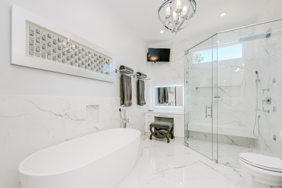 Large traditional ensuite bathroom in Los Angeles with shaker cabinets, white cabinets, a freestanding bath, a corner shower, white tiles, porcelain tiles, white walls, porcelain flooring, a submerged sink, engineered stone worktops, white floors and white worktops.