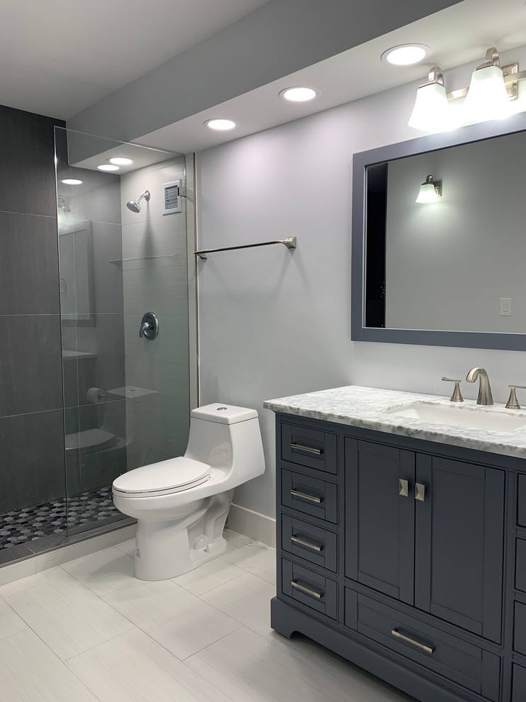 Exemple d'une salle de bain principale moderne de taille moyenne avec un placard en trompe-l'oeil, des portes de placard bleues, une baignoire en alcôve, une douche ouverte, WC à poser, un mur gris, un sol en carrelage de porcelaine, un lavabo encastré, un plan de toilette en marbre, un sol blanc, aucune cabine et un plan de toilette multicolore.