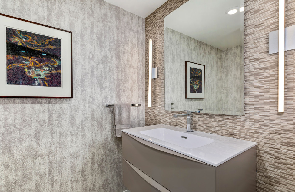 Esempio di una stanza da bagno minimal con ante lisce, ante grigie, piastrelle beige, piastrelle marroni, piastrelle a listelli, pareti grigie, lavabo integrato, top in superficie solida e top bianco