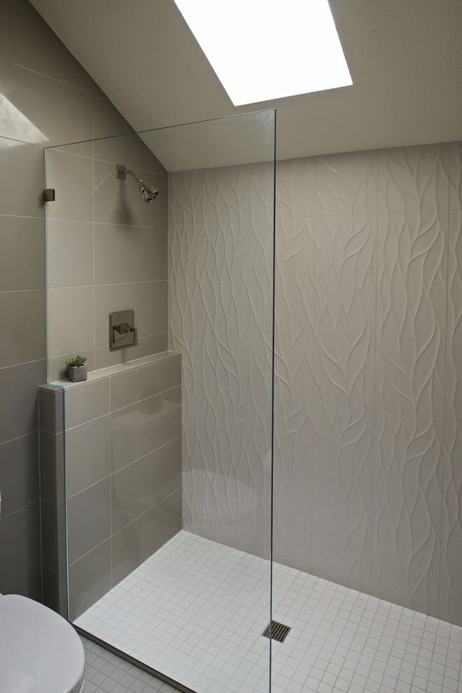 Modern inredning av ett mellanstort en-suite badrum, med ett undermonterad handfat, släta luckor, grå skåp, bänkskiva i kvarts, en öppen dusch, grå kakel, porslinskakel, grå väggar och klinkergolv i porslin