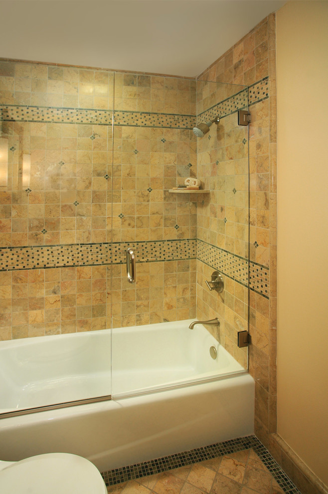 Esempio di una stanza da bagno american style di medie dimensioni con vasca ad alcova, vasca/doccia, piastrelle multicolore, piastrelle in pietra, WC monopezzo, pareti beige e pavimento in marmo