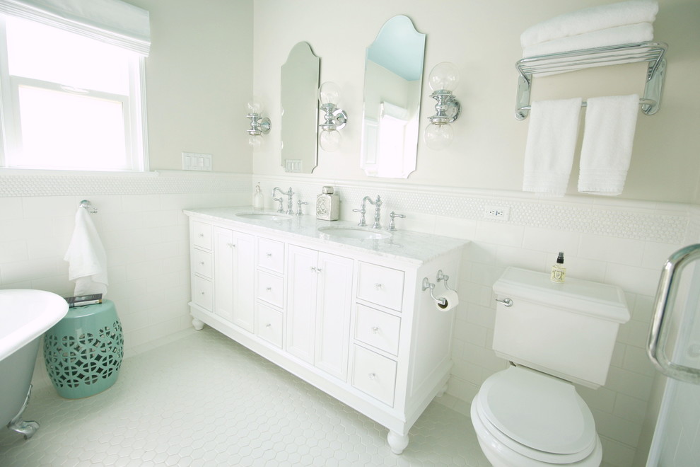 Klassisk inredning av ett mellanstort en-suite badrum, med ett undermonterad handfat, skåp i shakerstil, vita skåp, marmorbänkskiva, ett badkar med tassar, en toalettstol med hel cisternkåpa, vit kakel, tunnelbanekakel, grå väggar och klinkergolv i porslin