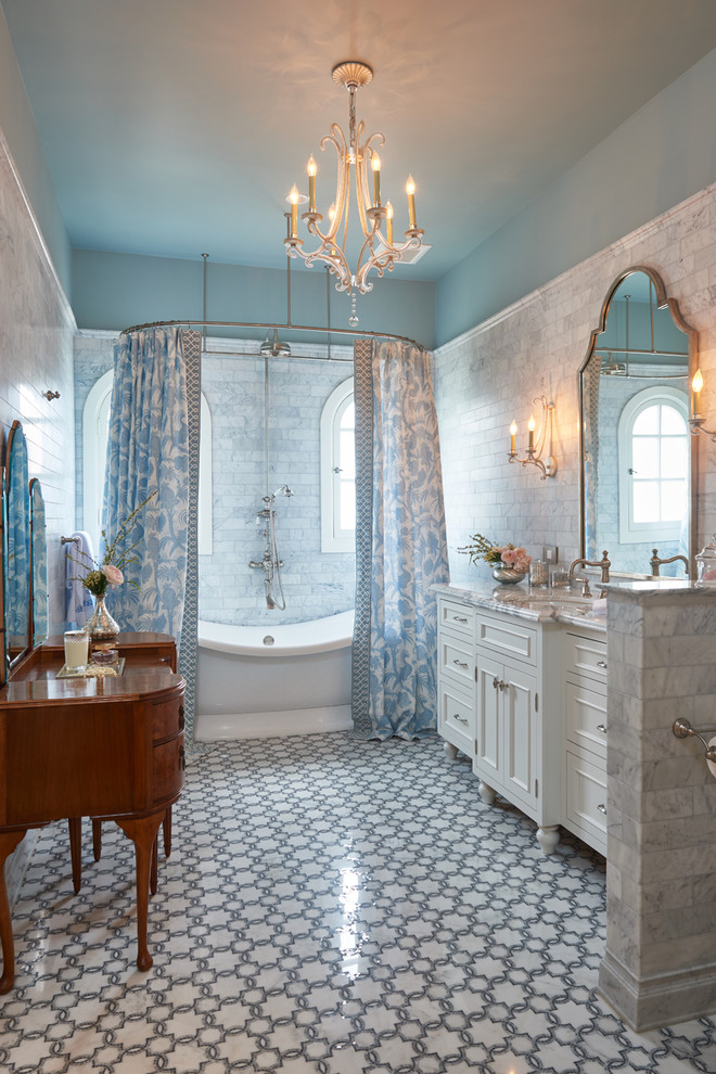 На фото: ванная комната в классическом стиле с белыми фасадами, отдельно стоящей ванной, душем над ванной, серой плиткой, мраморной плиткой, синими стенами, врезной раковиной, разноцветным полом, шторкой для ванной, серой столешницей и фасадами с утопленной филенкой