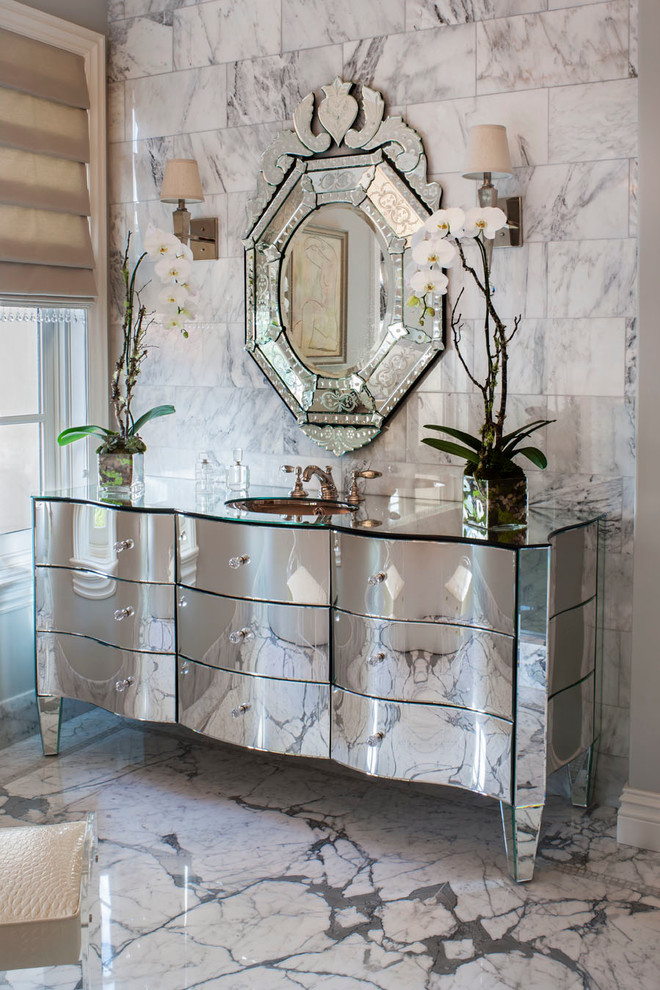 Пример оригинального дизайна: главная ванная комната в стиле неоклассика (современная классика) с врезной раковиной, стеклянной столешницей, плиткой из листового камня, мраморным полом и плоскими фасадами