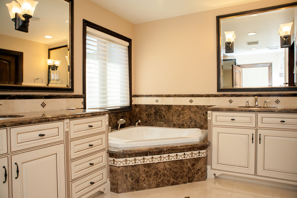 Foto på ett stort medelhavsstil en-suite badrum, med ett undermonterad handfat, skåp i shakerstil, beige skåp, marmorbänkskiva, ett hörnbadkar, en öppen dusch, en bidé, beige kakel, stenkakel, beige väggar och marmorgolv