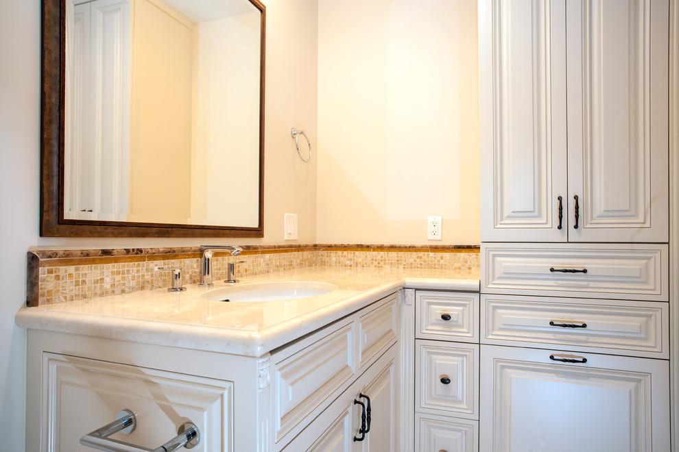 Mid-sized tuscan kids' beige tile and glass tile marble floor bathroom photo in Los Angeles with an undermount sink, raised-panel cabinets, white cabinets, granite countertops, a bidet and beige walls