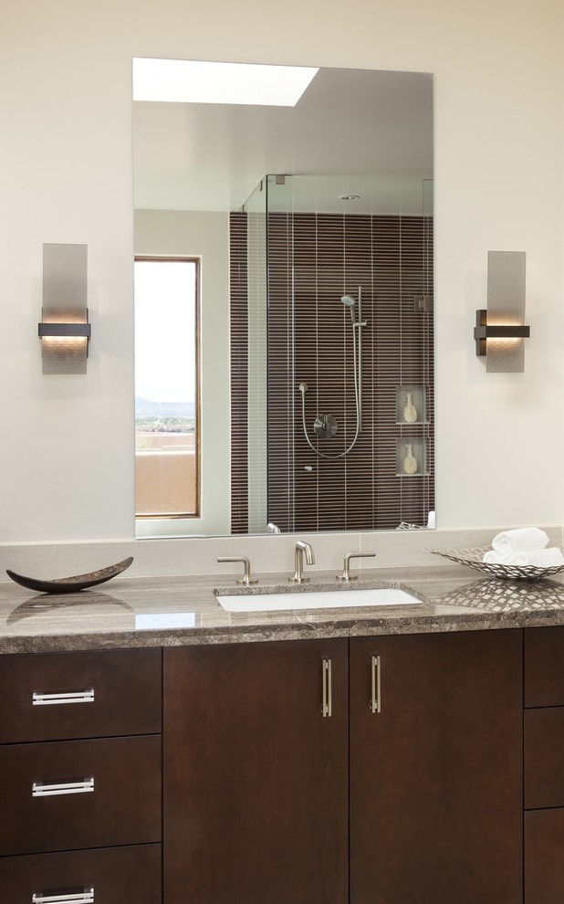 Idée de décoration pour une salle de bain principale design en bois foncé de taille moyenne avec un placard à porte plane, un mur blanc, un lavabo encastré et un plan de toilette en granite.