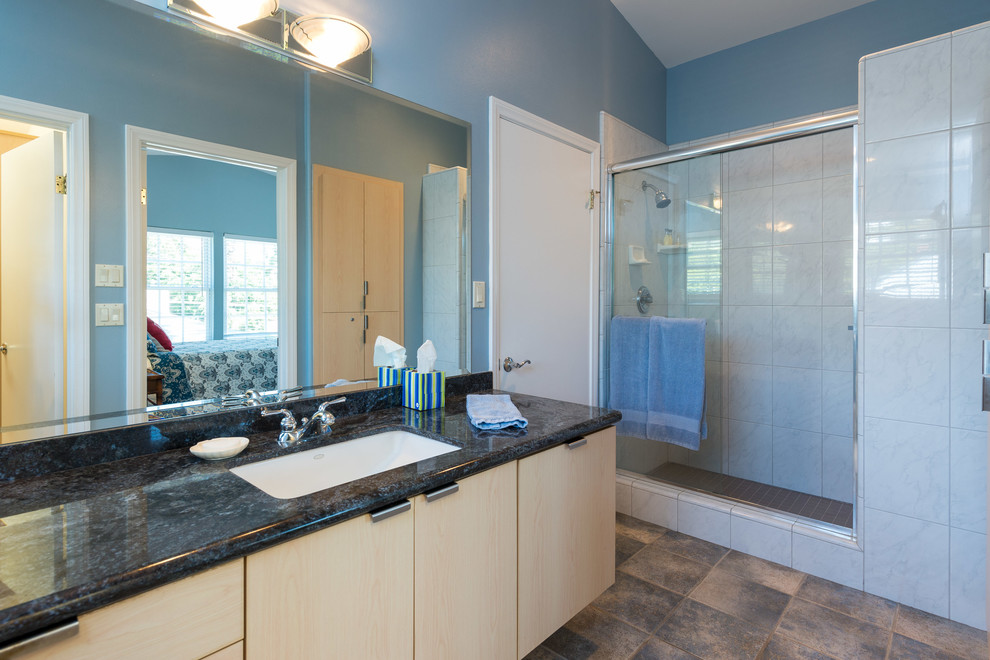 Идея дизайна: ванная комната среднего размера в морском стиле с врезной раковиной, плоскими фасадами, светлыми деревянными фасадами, столешницей из гранита, ванной в нише, душем в нише, унитазом-моноблоком, белой плиткой, керамогранитной плиткой, синими стенами, полом из травертина и душевой кабиной