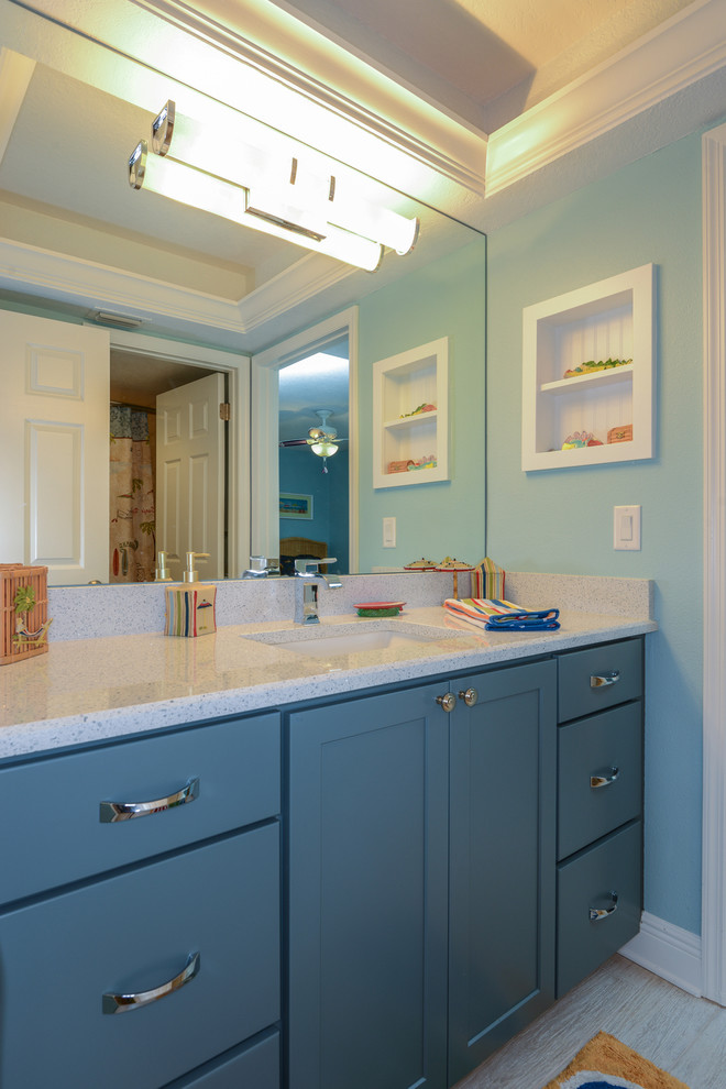 Ispirazione per una stanza da bagno per bambini costiera con lavabo sottopiano, ante con riquadro incassato, ante blu, top in granito, piastrelle grigie e pareti blu
