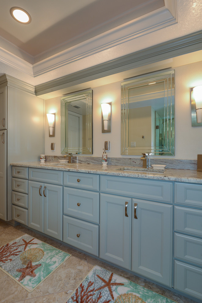 Maritimes Badezimmer En Suite mit Schrankfronten mit vertiefter Füllung, blauen Schränken, Granit-Waschbecken/Waschtisch, beigen Fliesen, beiger Wandfarbe und Keramikboden in Tampa