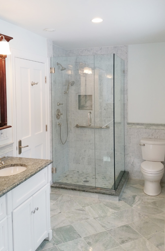 Inredning av ett lantligt mellanstort badrum med dusch, med luckor med infälld panel, vita skåp, en toalettstol med hel cisternkåpa, vit kakel, marmorkakel, vita väggar, marmorgolv, ett undermonterad handfat, granitbänkskiva, flerfärgat golv och dusch med gångjärnsdörr