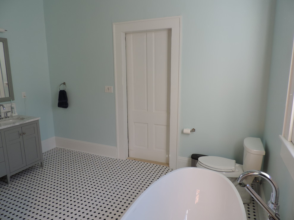 Exemple d'une douche en alcôve principale chic de taille moyenne avec un placard à porte shaker, des portes de placard grises, une baignoire indépendante, WC à poser, un mur bleu, un sol en carrelage de terre cuite, un lavabo encastré, un plan de toilette en marbre, un sol multicolore et aucune cabine.