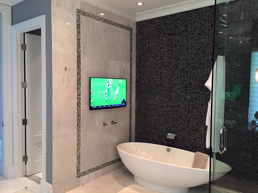 Foto på ett funkis en-suite badrum, med ett fristående badkar, en hörndusch, svart kakel och grå väggar