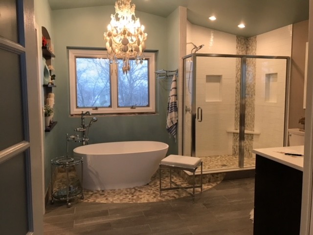Пример оригинального дизайна: огромная главная ванная комната в современном стиле с темными деревянными фасадами, отдельно стоящей ванной, душем в нише, бежевой плиткой, белой плиткой, галечной плиткой, синими стенами, полом из керамогранита, столешницей из искусственного кварца, бежевым полом, душем с распашными дверями и белой столешницей