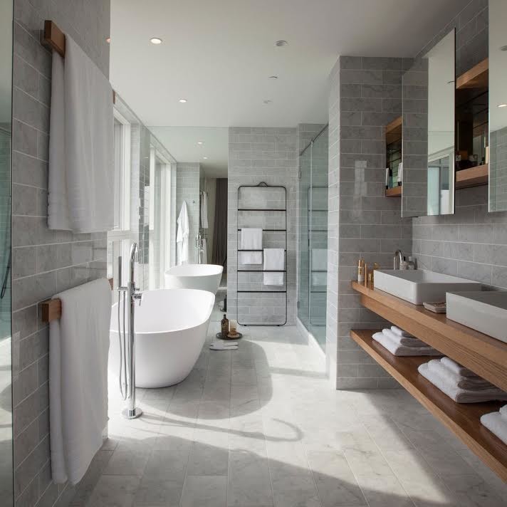 Foto di una grande stanza da bagno padronale minimal con vasca freestanding, doccia alcova, piastrelle grigie, piastrelle in gres porcellanato, top in legno e porta doccia scorrevole