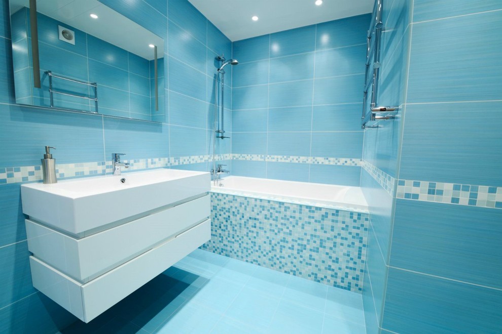 Inspiration for a mid-sized contemporary master blue tile and porcelain tile porcelain tile and blue floor bathroom remodel in San Francisco with white cabinets, blue walls, an integrated sink, a one-piece toilet, flat-panel cabinets, solid surface countertops and white countertops
