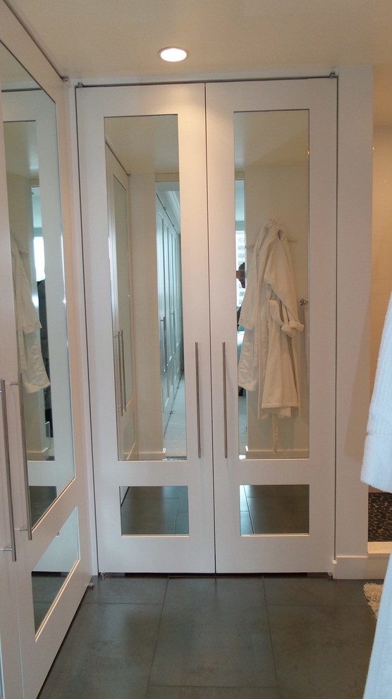 Foto de cuarto de baño actual pequeño con armarios tipo vitrina, puertas de armario blancas, encimera de vidrio, ducha esquinera y suelo de baldosas de porcelana