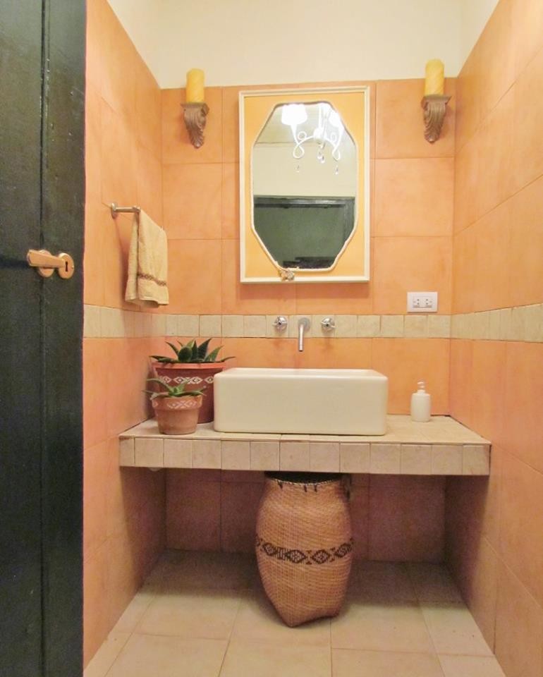 Стильный дизайн: ванная комната в стиле фьюжн с оранжевой плиткой и раковиной с несколькими смесителями - последний тренд