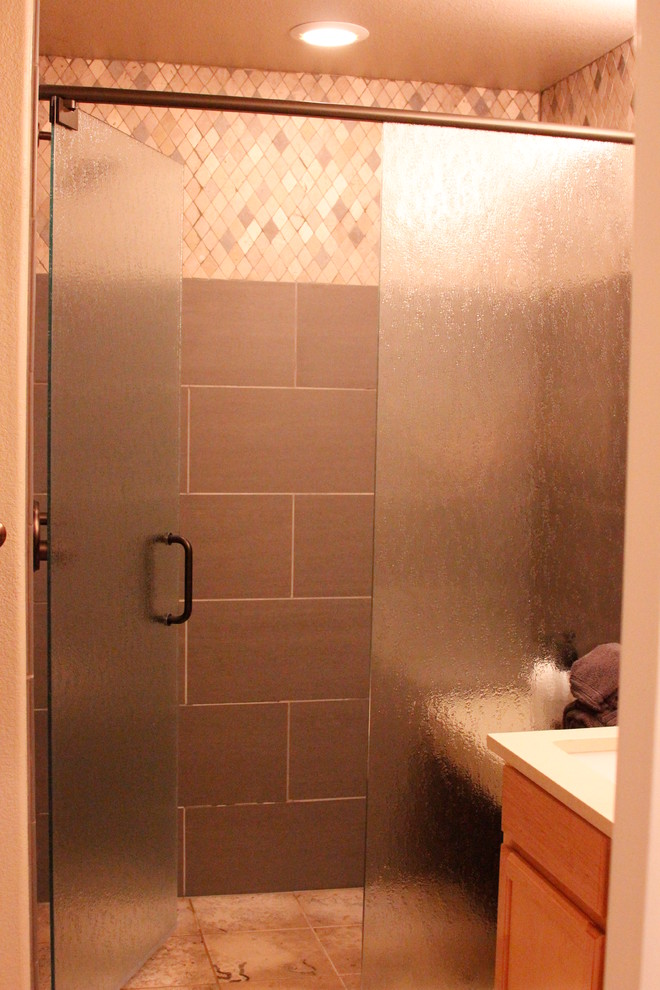 Esempio di una stanza da bagno con doccia classica di medie dimensioni con ante in stile shaker, ante in legno scuro, doccia alcova, piastrelle grigie, piastrelle in gres porcellanato, lavabo sottopiano, top in quarzite e porta doccia a battente