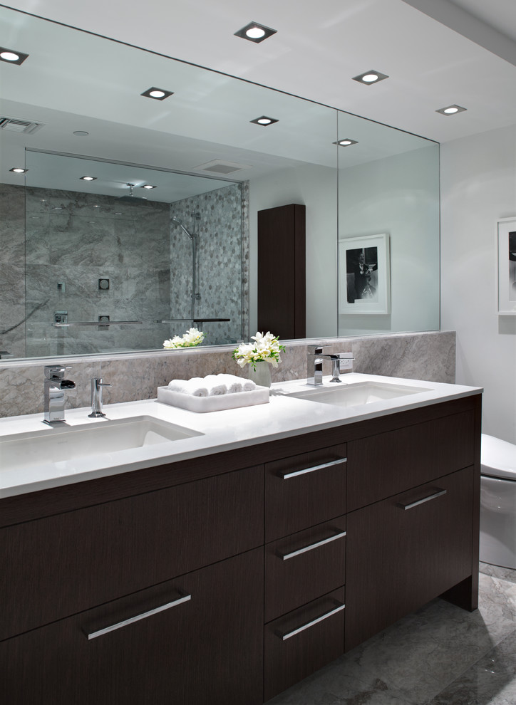 バンクーバーにあるコンテンポラリースタイルのおしゃれな浴室 (アンダーカウンター洗面器、フラットパネル扉のキャビネット、濃色木目調キャビネット、グレーのタイル、白い壁) の写真