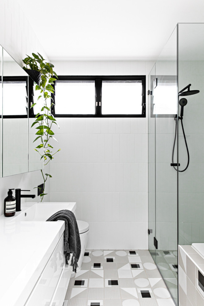 Пример оригинального дизайна: маленькая главная ванная комната в скандинавском стиле с белыми фасадами, накладной ванной, унитазом-моноблоком, белой плиткой, керамической плиткой, белыми стенами, полом из керамической плитки, подвесной раковиной, серым полом, душем с распашными дверями и белой столешницей для на участке и в саду