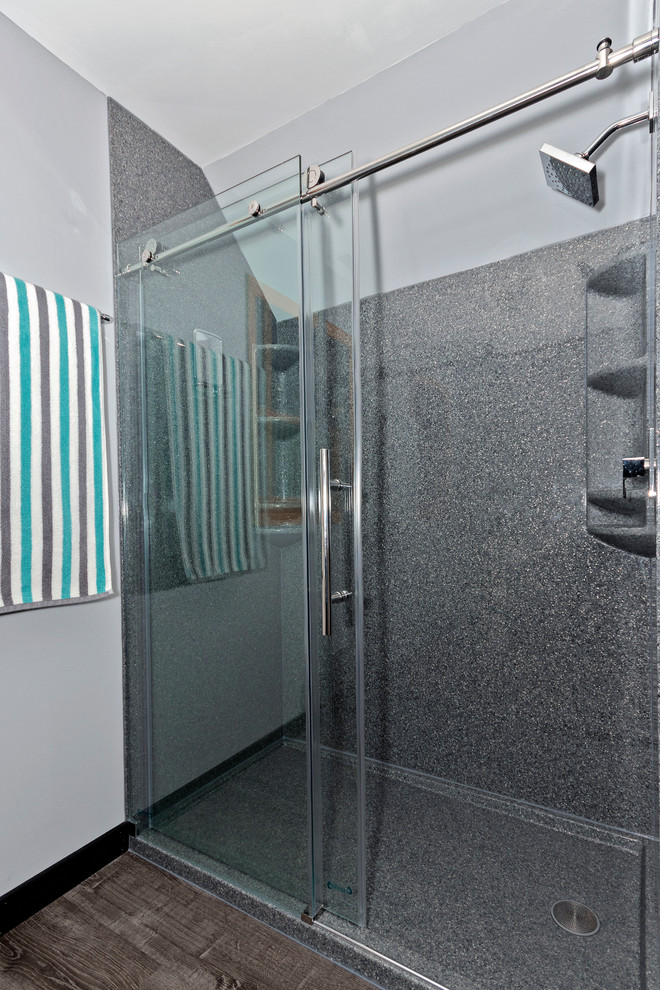 Inredning av ett modernt mellanstort grå grått en-suite badrum, med skåp i shakerstil, svarta skåp, en dusch i en alkov, en toalettstol med separat cisternkåpa, grå väggar, vinylgolv, ett integrerad handfat, bänkskiva i akrylsten, grått golv och dusch med skjutdörr